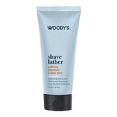 Woody's Shave Lather moisturizing shave cream in a light blue squeeze tube with a black cap, shown on a plain white background.