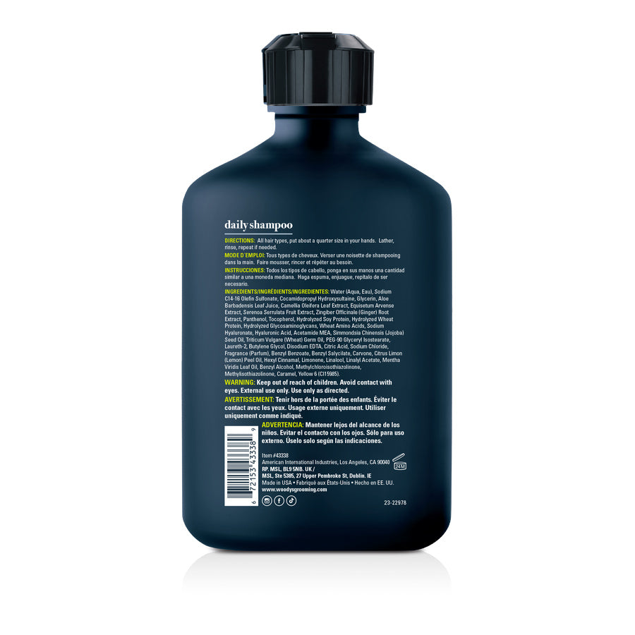The back of a dark blue bottle of daily shampoo with extensive white and yellow text, photographed on a clean white background.