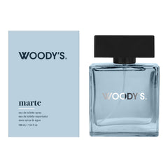 Woody's Marte Eau de Toilette bottle and packaging box. The bottle is made of clear glass with a light blue tint and a black cap, while the box is a pale blue with black text.