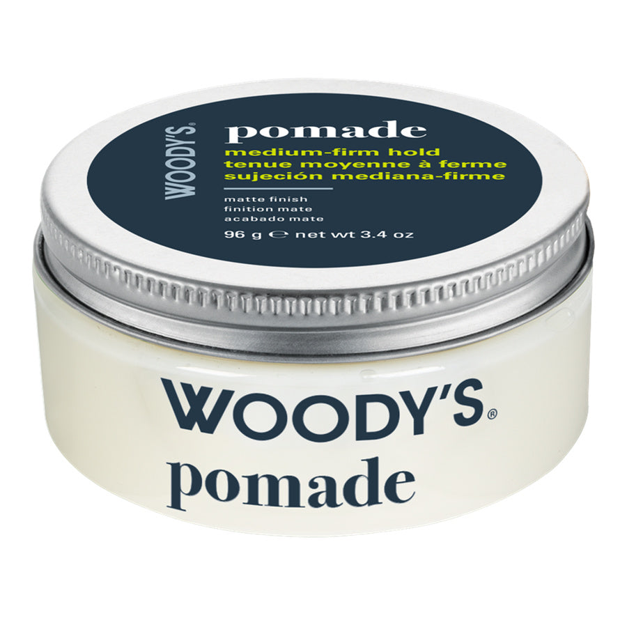 Woody's Pomade medium-firm hold hair wax in a round white plastic jar with a silver metal lid and a dark navy label.