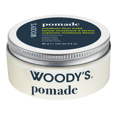 Woody's Pomade medium-firm hold hair wax in a round white plastic jar with a silver metal lid and a dark navy label.