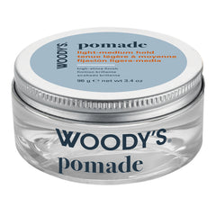 Woody's Pomade light-medium hold hair wax in a clear plastic jar with a silver metal lid and a light blue label.
