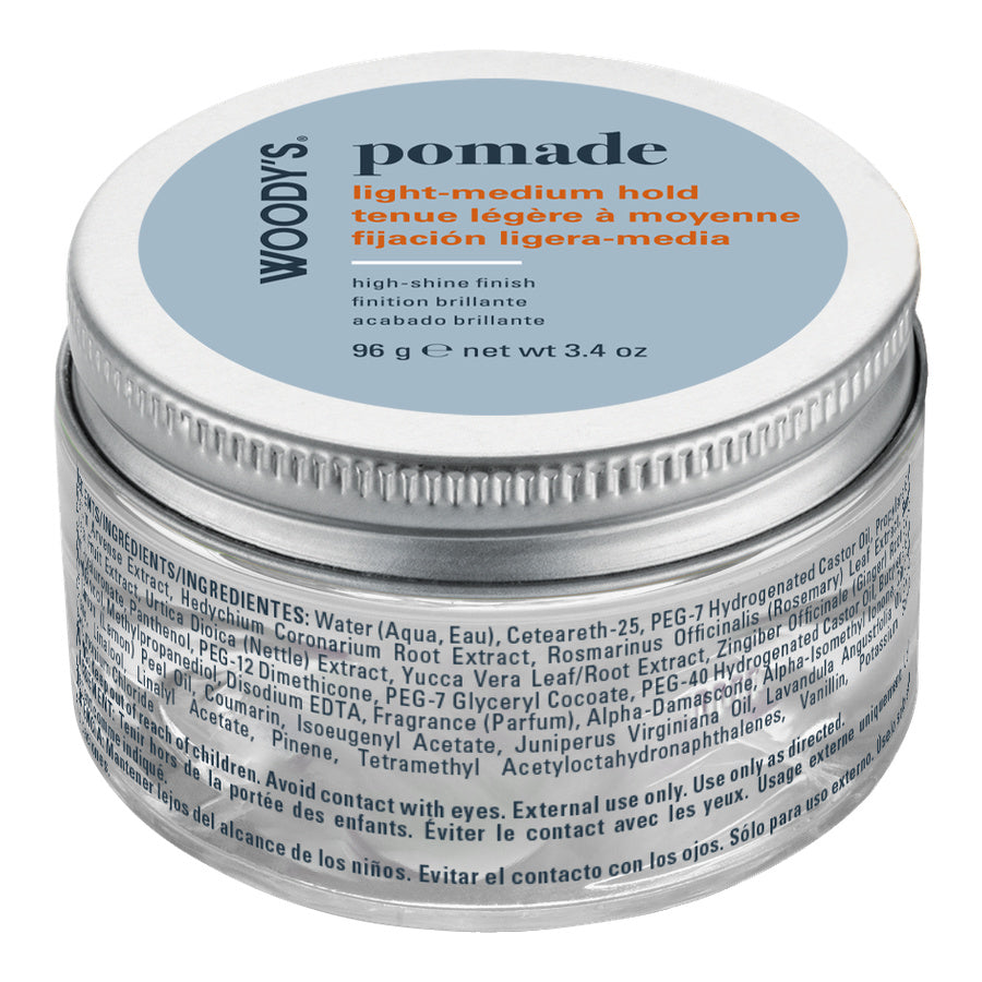 A silver metal jar of Woody's Pomade with a light blue lid label, photographed on a clean white background.