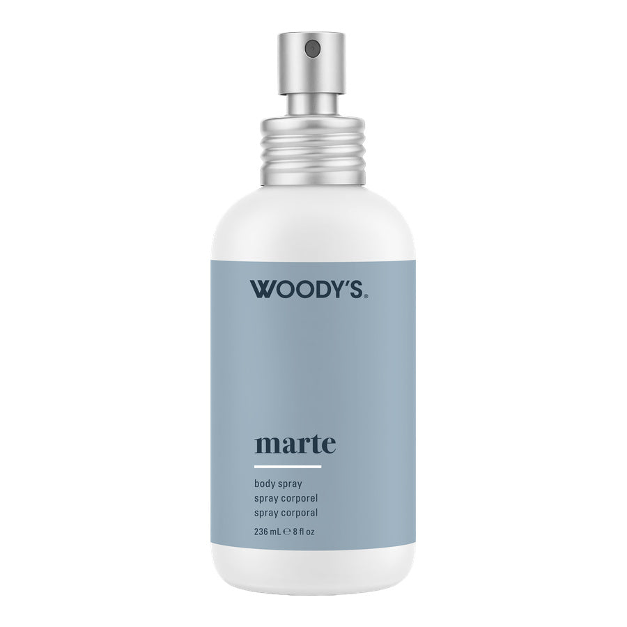 Woody's Marte body spray in a 226 mL white bottle with a matte slate blue label and a silver spray nozzle, shown on a plain white background.