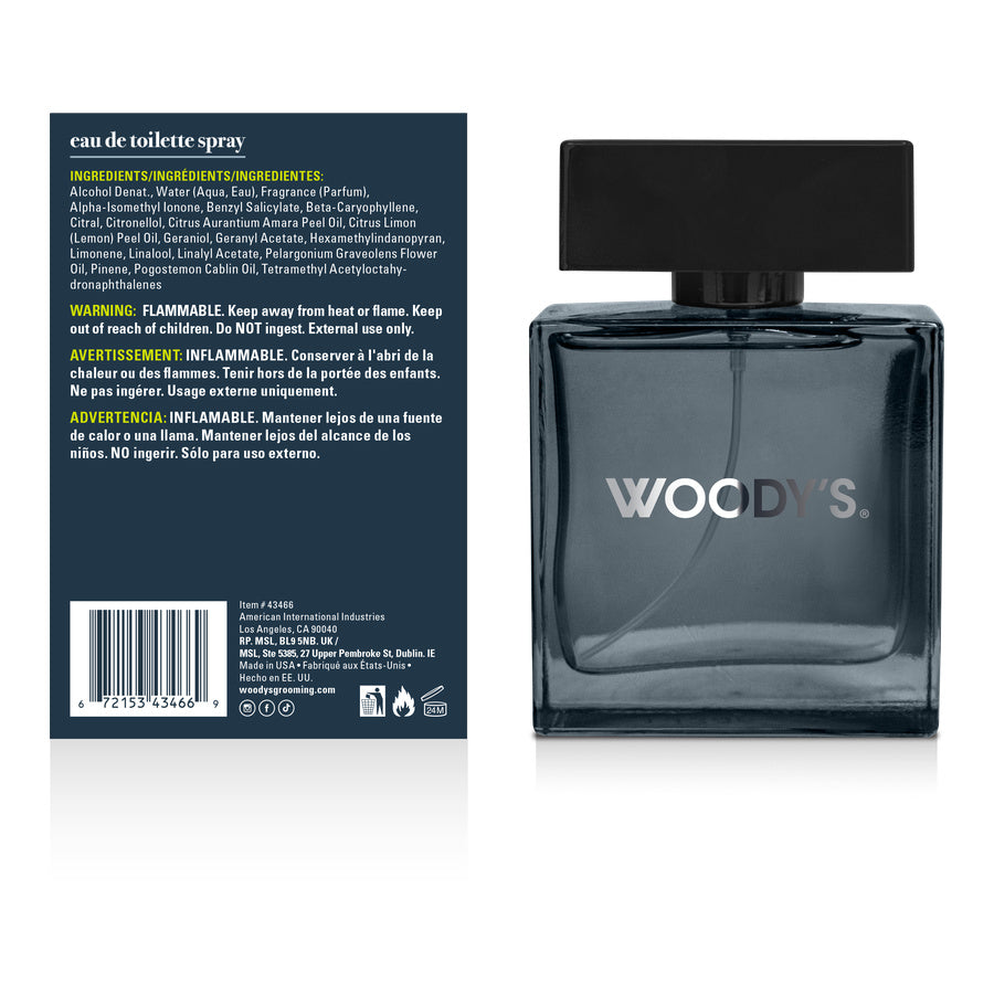Woody's Eau de Toilette Spray bottle shown from the front and back. The bottle is a dark smoky gray glass with a black cap, and the back panel is dark blue with product details and a barcode.