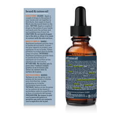 A bottle of beard and tattoo oil with a black dropper cap and amber glass bottle, shown next to its blue and white instruction card on a white background.